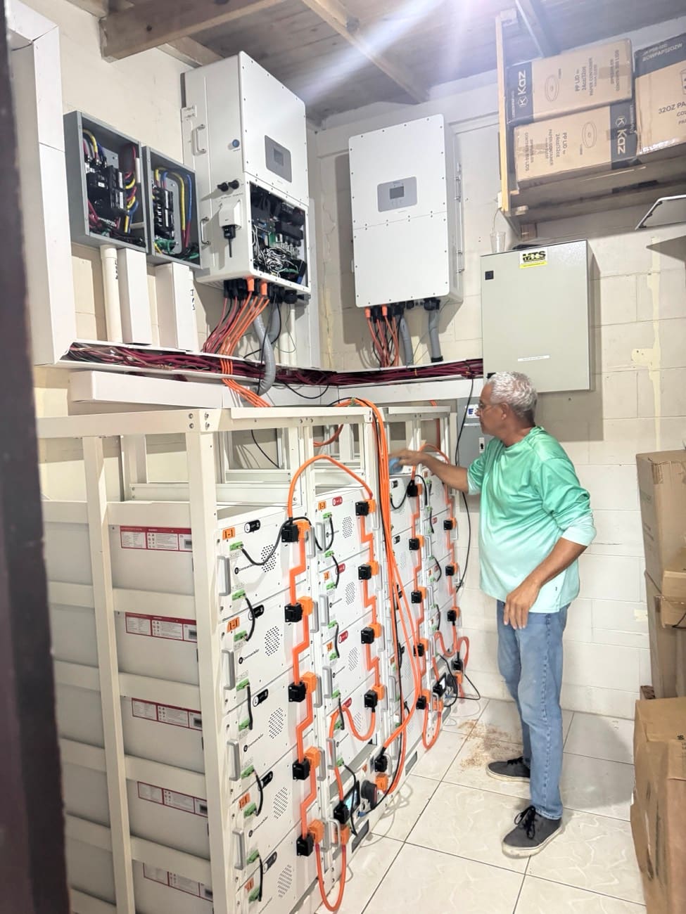 A wall-mounted battery bank wired into the inverter in a purpose-built plant room