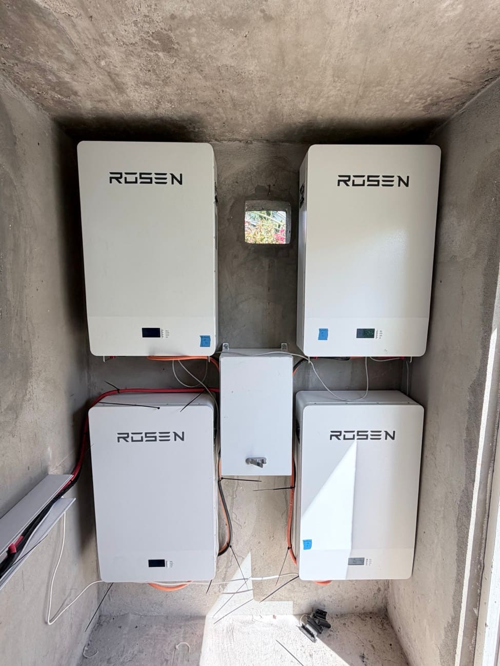 Four wall-mounted battery modules banked together in a concrete plant room